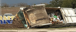 Garbage truck flips
