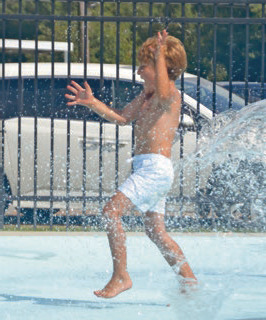 William Lafargue frolics through the many jets at the Welsh community splash pad. Officials are planning to open the water attraction for the season on Saturday. File photo