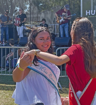 2026 Miss Eunice Queen Dashae Sittig (left) dances with 2025 Jeff Davis Parish Fair Queen Josie Bruchhaus during a performance by Steve Riley and the Mamou Playboys at Saturday’s festival.