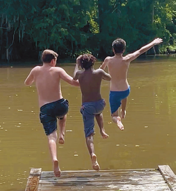 Aiden Michon (from left), 13, Jathaniel Arvie, 11, and Trenton Michon, 13, take a running jump off the dock at Houssiere Park as the three friends from Jennings take full advantage of the warm summer days. Daily News photo by D'Arcy Knight