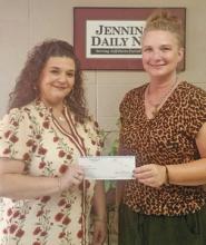 Jennie Hebert of Welsh (left) receives her $50 check from Classifieds Manager Jennifer Mouhot. Hebert correctly guessed the winning football teams in the Jennings Daily News You Pick Em weekly contest. Daily News photo by Erin Hargrave