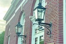 Historic wall sconces recently returned to the Jefferson Davis Parish Library after decades in storage. The restored fixtures now adorn the building's entrance, where the original “U.S. Post Office” inscription remains visible above the doorway, recalling the building’s earliest days before it became the parish library. Daily News photo by D'Arcy Knight
