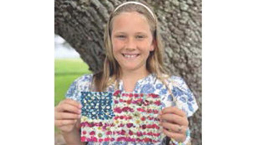 Local fourth grader Etta Landry proudly displays her work of art symbolizing what America means to her. The elementary student is the daughter of Ben and Amber Landry, the granddaughter of Tony and Sharon Comeaux, Todd and Sandy Landry and the great-granddaughter of Albert and Linda Wilson and Mary Landry, all of Jennings. Submitted photo