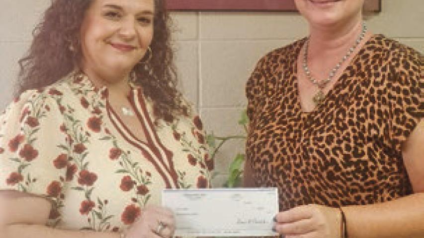 Jennie Hebert of Welsh (left) receives her $50 check from Classifieds Manager Jennifer Mouhot. Hebert correctly guessed the winning football teams in the Jennings Daily News You Pick Em weekly contest. Daily News photo by Erin Hargrave