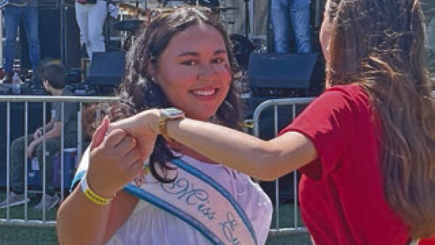 2026 Miss Eunice Queen Dashae Sittig (left) dances with 2025 Jeff Davis Parish Fair Queen Josie Bruchhaus during a performance by Steve Riley and the Mamou Playboys at Saturday’s festival.